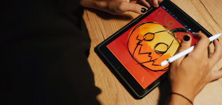 Creating a Halloween pumpkin illustration on a tablet with a stylus.